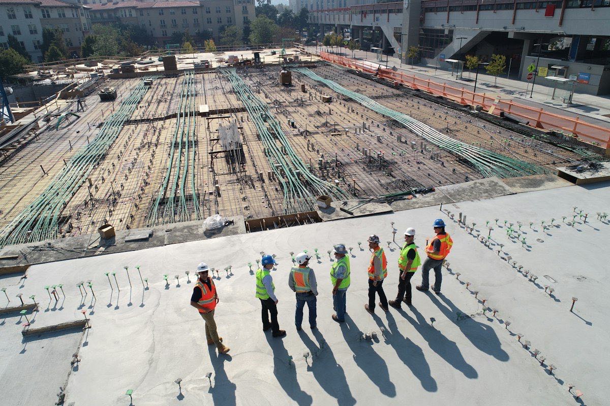 Site crew in hi-vis and hard hats on a reinforced-concrete work front
